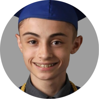 A close-up photo of a young man
											with short hair, a graduation cap,
											and a smile showing braces on
											their teeth. The individual has a
											light complexion and is wearing a
											dark graduation gown with a visible
											collar, with the background being
											a simple grey color.