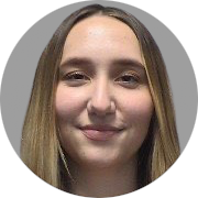A close-up photo of a young woman
										with a fair complexion and straight,
										long, blonde hair parted in the middle.
										The individual has a gentle smile and
										is looking directly at the camera.
										The background is a simple grey color.